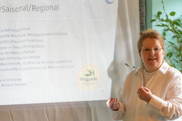 eine rothaarige Frau mit Brille hält einen Vortrag zum Thema gesunde Ernährung