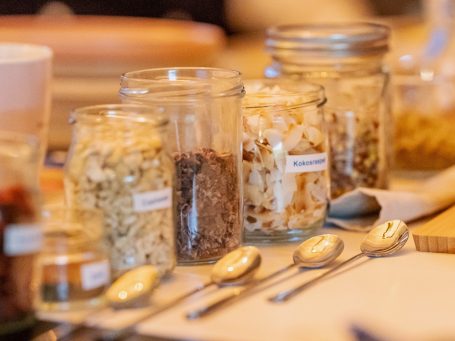 verschiedene Müsligläser und Löffel schon nebeneinander angerichtet