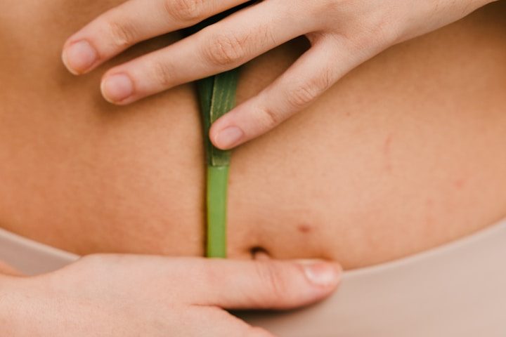 eine Frau legt beide Hände auf ihren Bauch